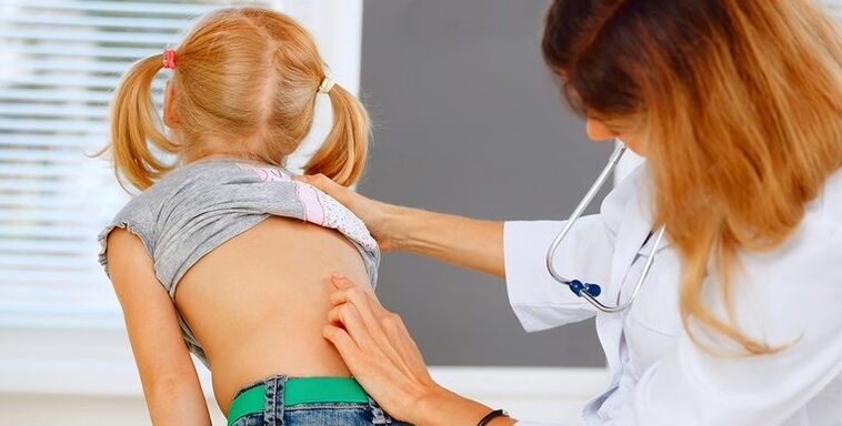 El médico examina la espalda del niño para detectar dolor lumbar